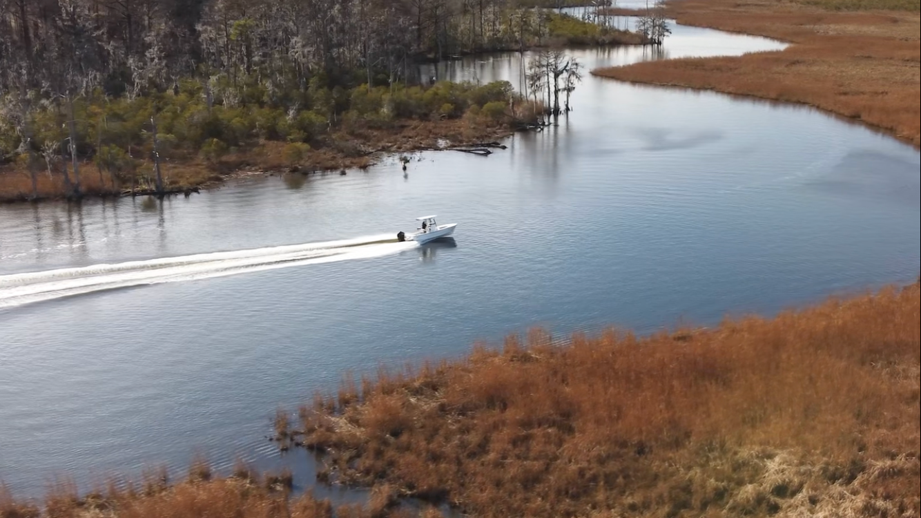 Swan Point boat running through a coastal creek